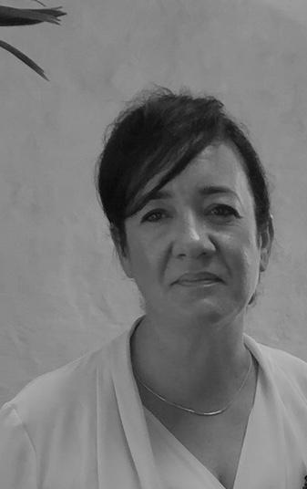 Professional woman with short dark hair wearing white blouse with silver necklace in black and white portrait